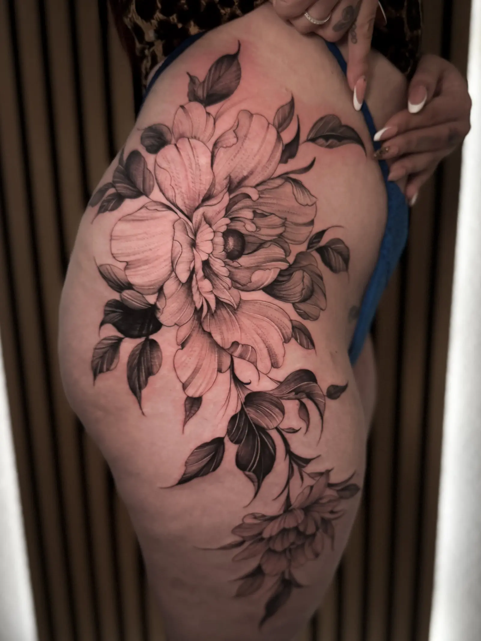 Fineline Blumen Tattoo am Oberschenkel